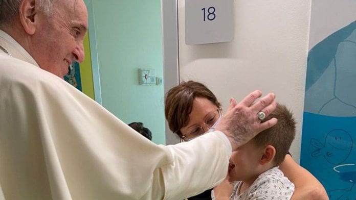 Popiežius Pranciškus laimina sergantį vaiką