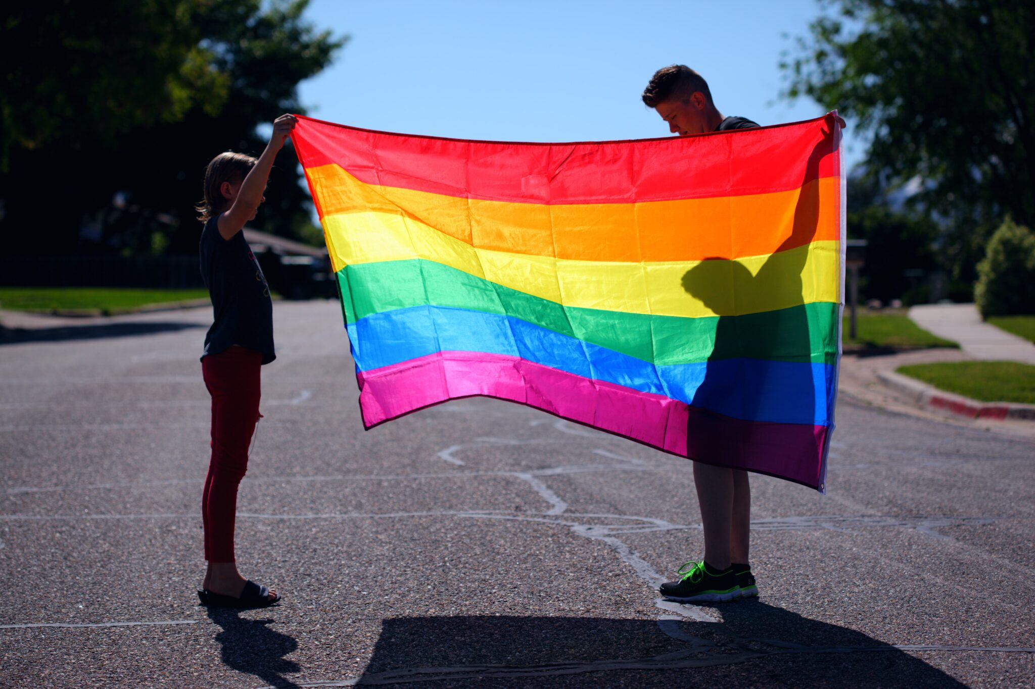 LGBTQ šeima laiko vėliavą / Unsplash nuotr.