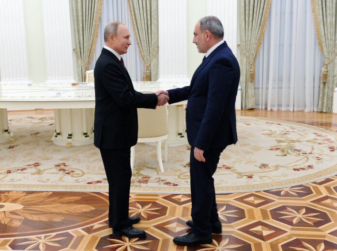 Rusijos prezidentas Vladimiras Putinas (kairėje) spaudžia ranką Armėnijos ministrui pirmininkui Nikolui Pašinianui prieš trišales derybas / EPA nuotr.