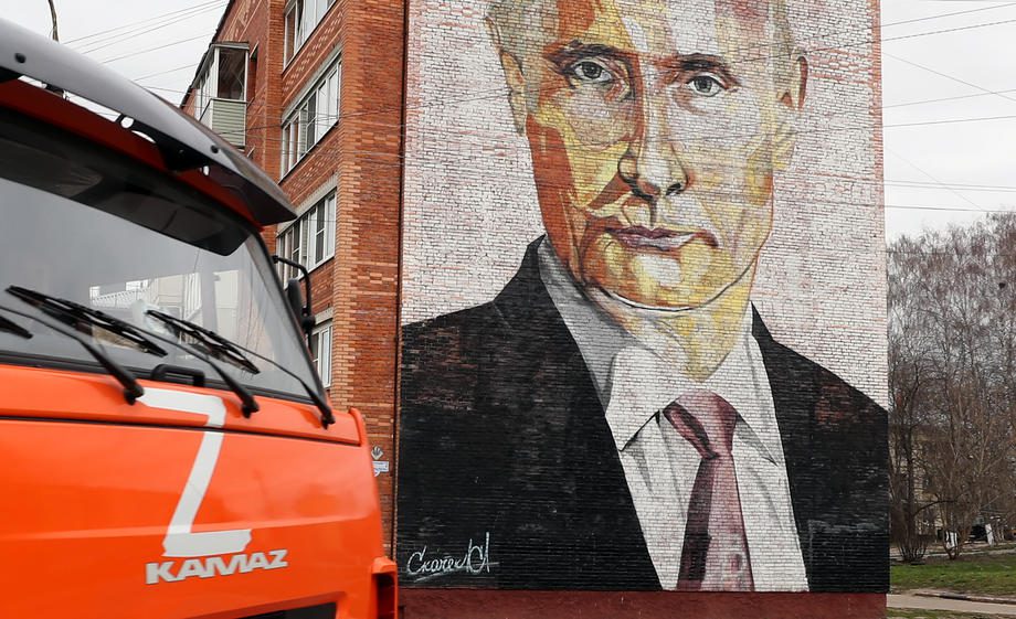 Sunkvežimis su Z raide važiuoja gatve priešais daugiabutį namą su Rusijos prezidento Vladimiro Putino atvaizdu Kaširos mieste, Rusijoje.