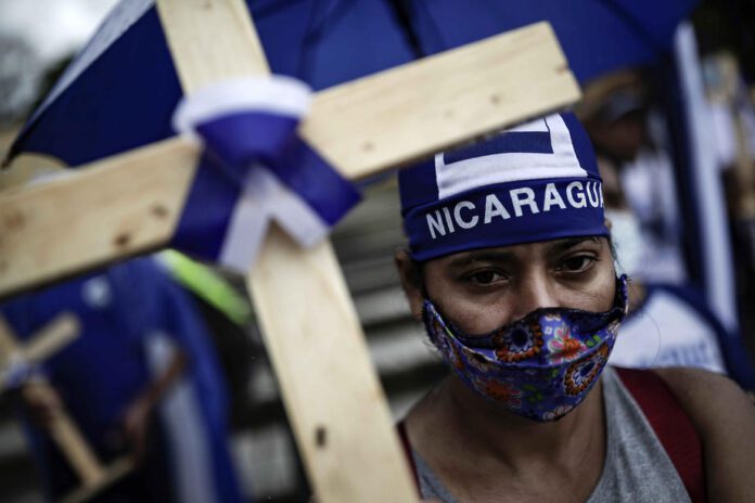 Protestuotojas Nikaragvoje laiko kryžių / EPA nuotr.