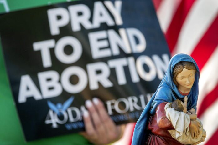 Religinė figūrėlė demonstruojama per maldos prieš abortus renginį per demonstracijas Floridos tarptautinio universiteto miestelyje Majamyje (Floridos valstija) / EPA nuotr.