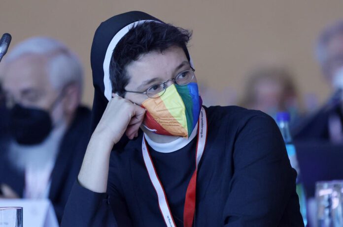 Sinodo kelio dalyvė dėvi LGBT vėliavos spalvų veido kaukę Vokietijos katalikų bažnyčios Sinodo asamblėjos susitikimo metu Frankfurte, Vokietijoje / EPA nuotr.