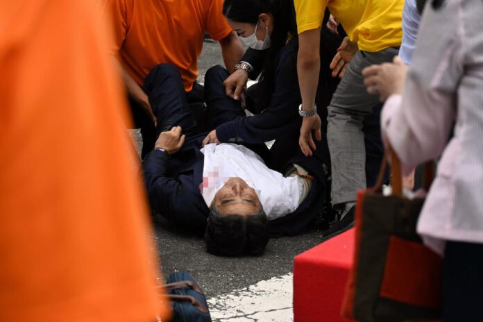 Buvęs Japonijos ministras pirmininkas Shinzo Abe guli ant žemės po to, kai buvo nušautas prie Jamato-Saidaiji stoties Naroje, Japonijoje / EPA nuotr.