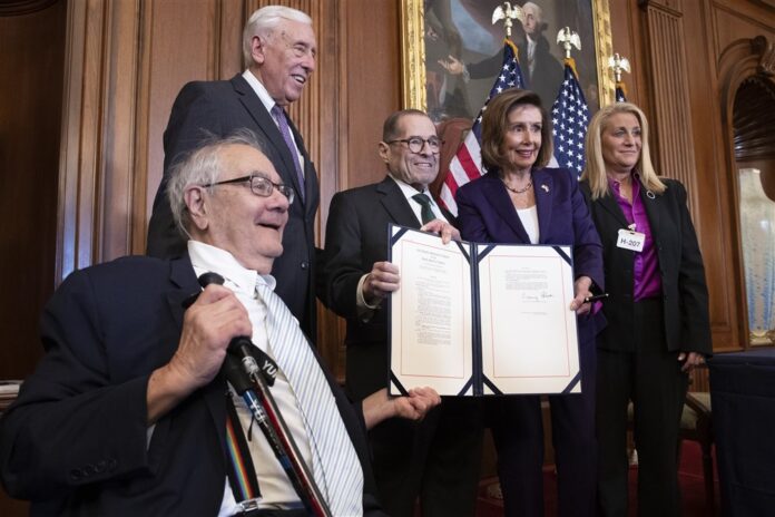 JAV Atstovų Rūmų pirmininkė Nancy Pelosi (antra iš dešinės) su įstatymo projektu šalia pirmojo atvirai homoseksualaus Kongreso nario Barney Frank / EPA nuotr.
