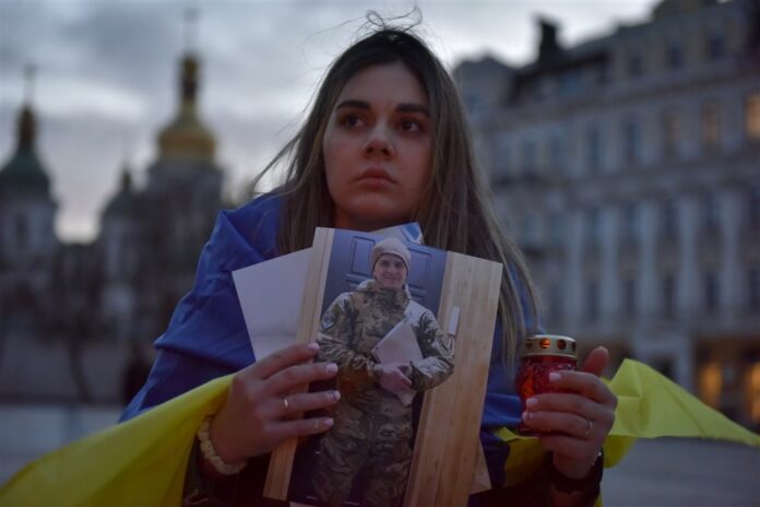 Ukrainietė su vyro, paimto į nelaisvę Mariupolio Azovstalyje, portretu / EPA nuotr.