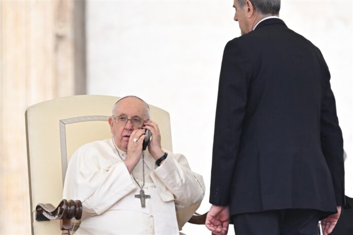 Popiežius Pranciškus trumpam nutraukė trečiadienio bendrąją audienciją, kad galėtų atsiliepti į telefono skambutį / EPA nuotr.