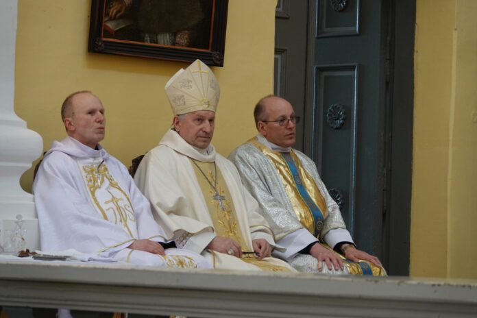 Prieš sumą, skambant choro giesmei, iškilmingai atlydėtas garbus parapijos svečias Vilkaviškio vyskupas Rimantas Norvila (viduryje) / Vilkaviškio vyskupijos nuotr.