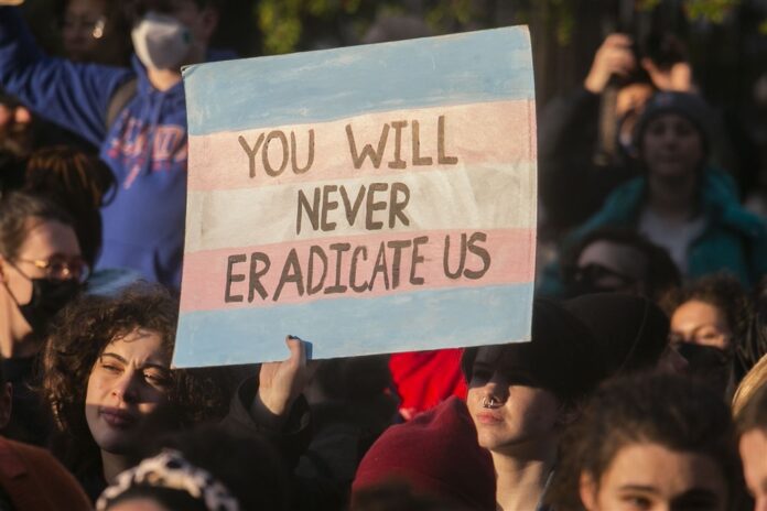 Tarptautinė translyčių asmenų matomumo diena Niujorke, plakatas su užrašu „Niekada mūsų neatsikratysite