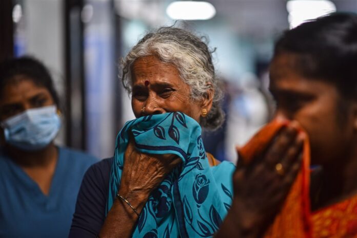 Moteris verkia sužeisto sūnaus Indijos traukinio avarijos metu / EPA nuotr.
