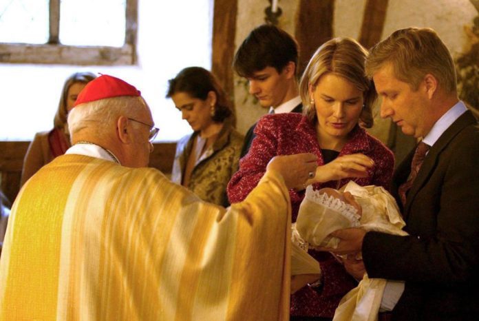 Belgijos princas Filipas (dešinėje) ir princesė Matilda laiko savo sūnų princą Gabrielį, kurį pakrikštijo kardinolas Godfriedas Daneelsas (kairėje), 2003 m. spalio 25d. Ciergnone / EPA nuotr.
