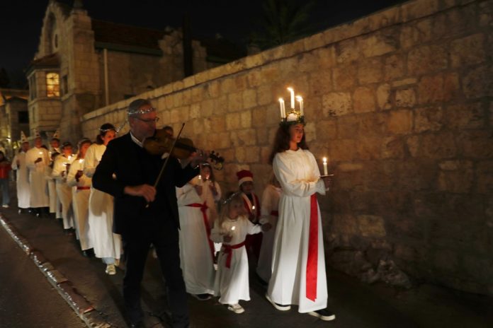 Švedijos Bažnyčios Jeruzalėje organizuota Šv. Liucijos dienos procesija Švedijos teologijos institute, 2022 m. gruodžio 13 d. / EPA nuotr.