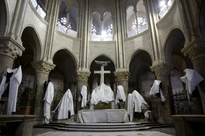 Paryžiaus Dievo Motinos katedros centre stovi brezentu apsaugotos statulos, nes Paryžiuje, Prancūzijoje, gruodžio 8 d., tęsiasi katedros restauravimo darbai / EPA nuotr.