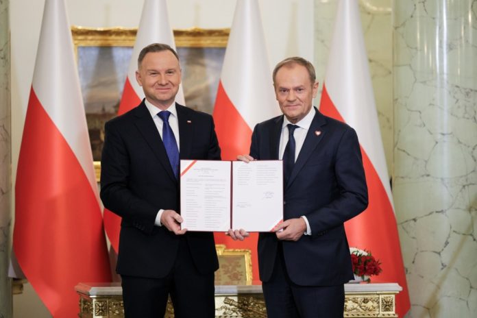 Lenkijos prezidentas Andrzejus Duda (kairėje) skiria Donaldą Tuską (dešinėje) Lenkijos ministru pirmininku naujojoje vyriausybėje per ceremoniją Prezidento rūmuose Varšuvoje (Lenkija) / EPA nuotr.