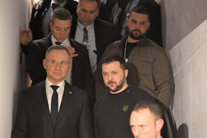 Lenkijos prezidentas Andrzejus Duda (kairėje apačioje) ir Ukrainos prezidentas Volodymyras Zelenskis (apačioje dešinėje) parodos apie Rusijos karo nusikaltimus Ukrainoje atidaryme per Pasaulio ekonomikos forumo 54-ąjį metinį susitikimą Davose, Šveicarijoje, 2024 m. sausio 16 d. / EPA nuotr.
