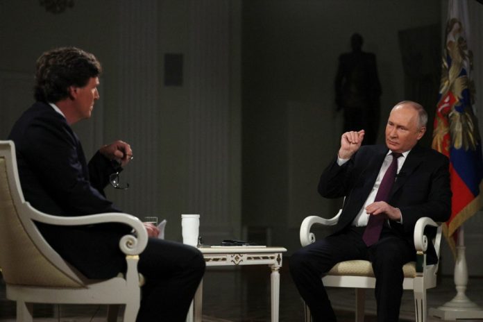 JAV pokalbių laidų vedėjas Tuckeris Carlsonas ir Rusijos prezidentas Vladimiras Putinas interviu metu / EPA nuotr.
