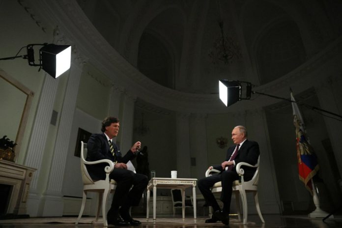 JAV pokalbių laidų vedėjas Tuckeris Carlsonas ir Rusijos prezidentas Vladimiras Putinas interviu metu / EPA nuotr.