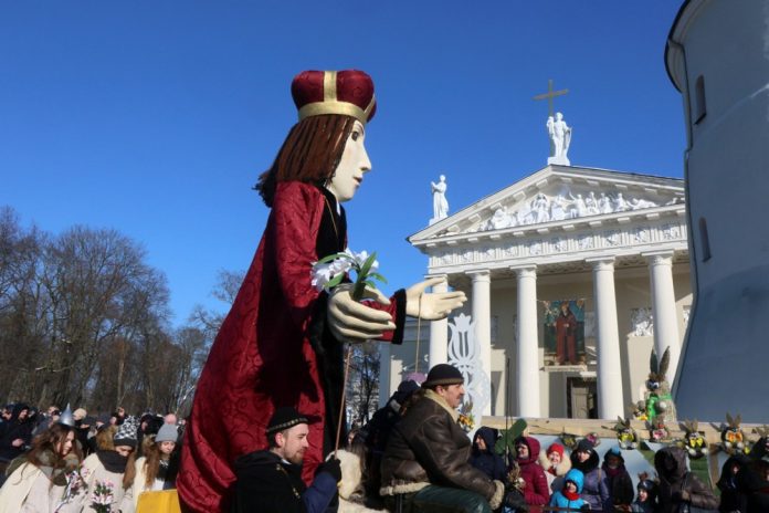 Žmonės stebi šventojo Kazimiero statulą, nešamą šventinėje eisenoje per Kaziuko mugę Vilniuje, 2018 m. kovo 4 d. / EPA nuotr.