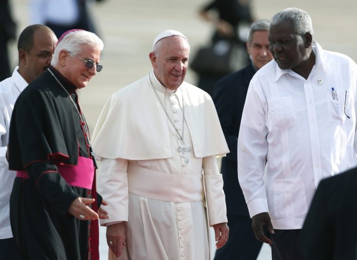 Popiežius Pranciškus (centre) su Kubos arkivyskupu Dionisio Guillermo Garcia (kairėje) ir Kubos parlamento pirmininku Estebanu Lazo (dešinėje) Antonio Maceo Kubos oro uoste, 2015 m. rugsėjo 21 d. / EPA nuotr.