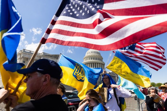 Ukrainos rėmėjai mojuoja JAV ir Ukrainos vėliavomis prie JAV Kapitolijaus po to, kai Atstovų Rūmai patvirtino užsienio pagalbos paketus Ukrainai, taip pat Izraeliui ir Taivanui JAV Kapitolijuje Vašingtone, 2024 m. balandžio 20 d.