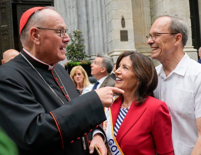 Kardinolas Timothy Dolanas (kairėje), Niujorko gubernatorė Kathy Hochul (centre) ir jos vyras Williamas J. Hochul / EPA nuotr.