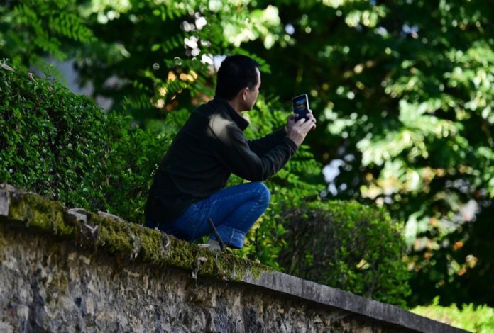 Vyras su telefonu Paryžiuje, Prancūzijoje / EPA nuotr.